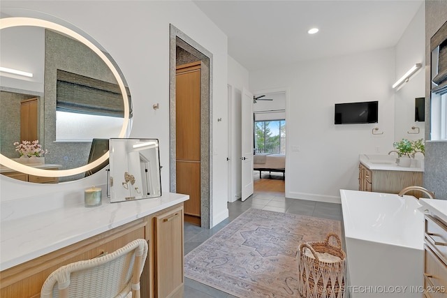 bathroom with a bathing tub, tile patterned flooring, and vanity