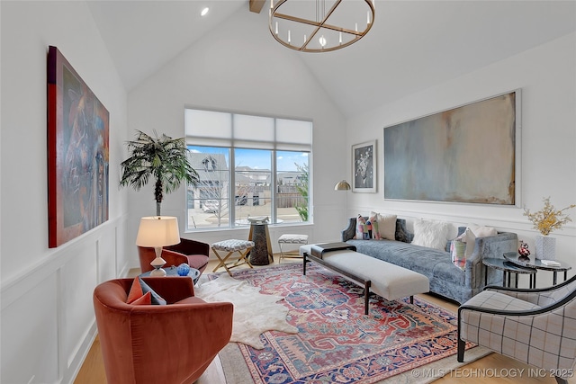 living room featuring hardwood / wood-style flooring, high vaulted ceiling, and an inviting chandelier