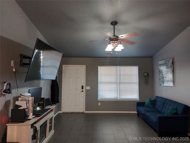 living room featuring ceiling fan and a textured ceiling