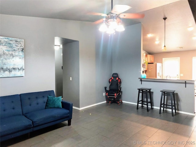 living room with ceiling fan and lofted ceiling