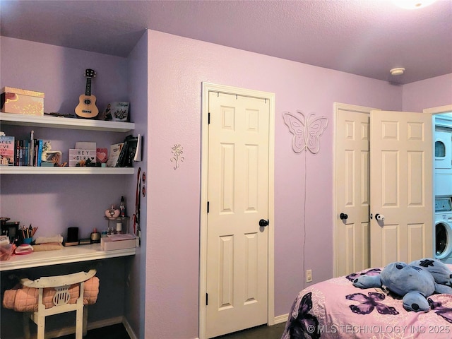 bedroom with stacked washer / dryer