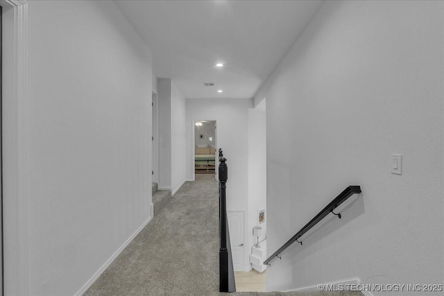 hallway featuring light colored carpet