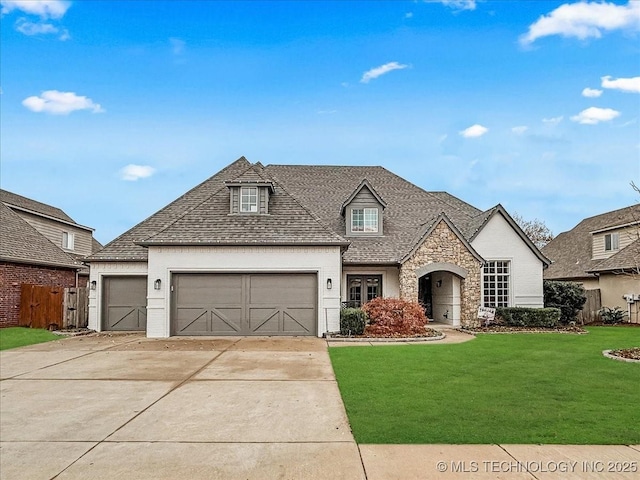 french country home with a front lawn and a garage