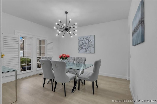 dining room with light hardwood / wood-style floors and a notable chandelier