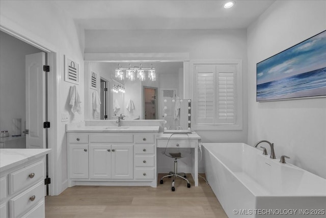 bathroom featuring wood-type flooring, vanity, and a bathtub