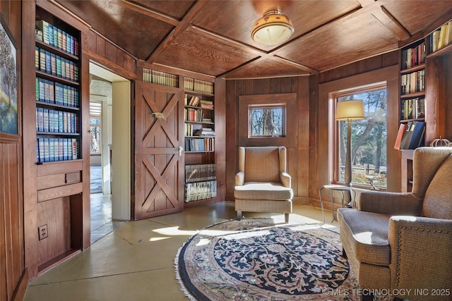 living area featuring built in features, a wealth of natural light, wood walls, and wood ceiling