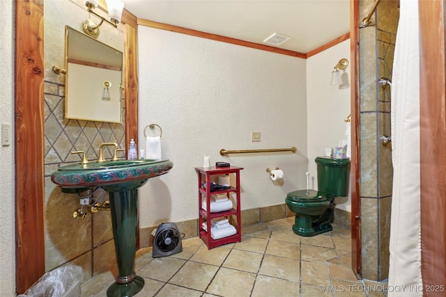 bathroom with decorative backsplash, crown molding, sink, tile patterned flooring, and toilet