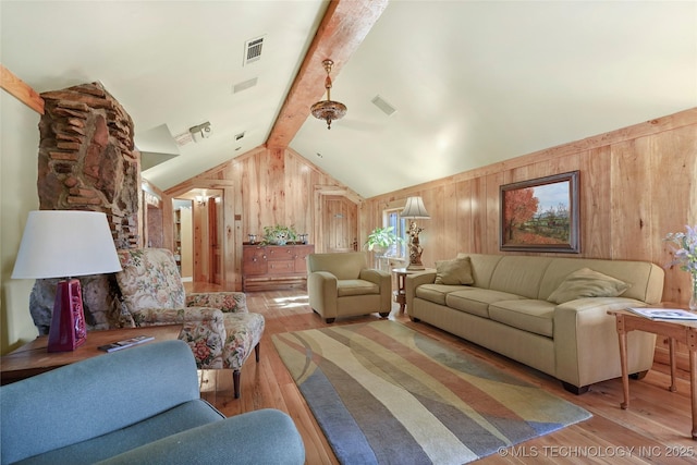 living room featuring vaulted ceiling with beams and light wood-type flooring