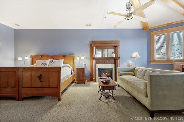 carpeted bedroom with a tiled fireplace and ceiling fan