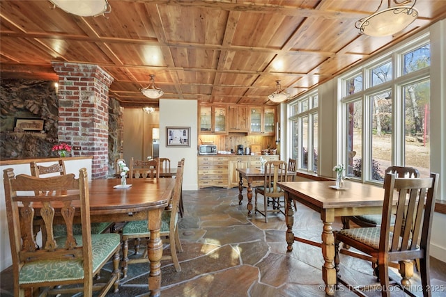 dining room with decorative columns and wooden ceiling