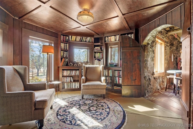 sitting room with built in shelves, wood walls, wood ceiling, and coffered ceiling