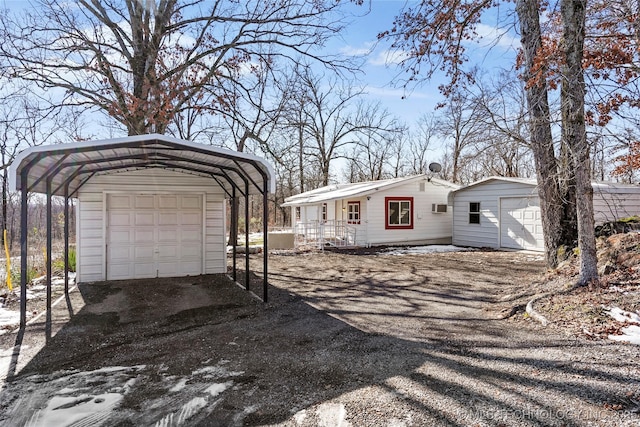 view of front of house featuring a carport and an outbuilding