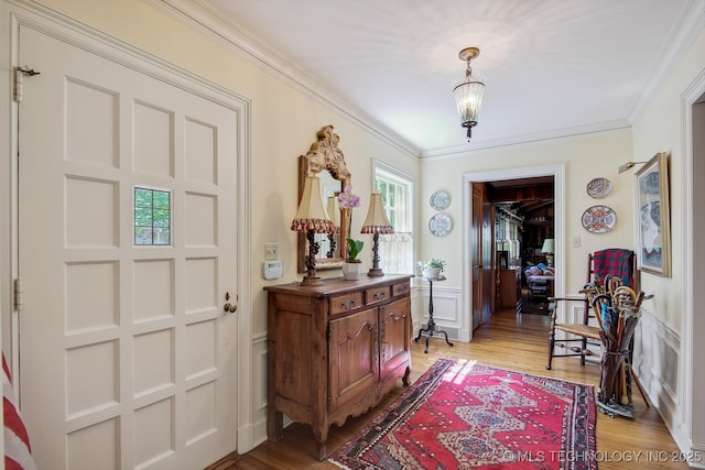 entrance foyer with a notable chandelier, light hardwood / wood-style floors, and ornamental molding