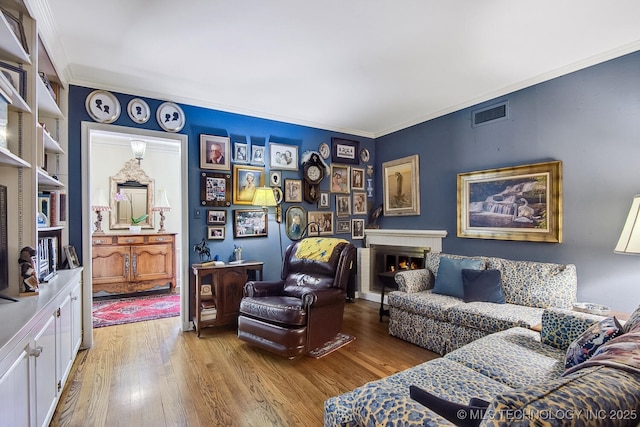 living room with light wood-type flooring and crown molding