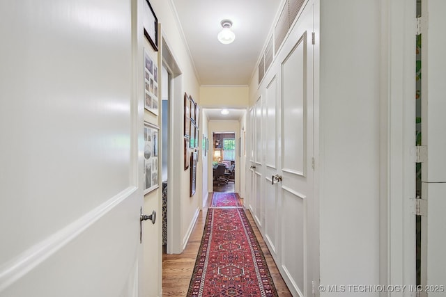 hall with light hardwood / wood-style flooring and ornamental molding