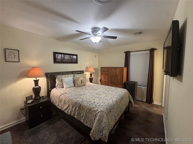 bedroom featuring a textured ceiling, ceiling fan, and dark hardwood / wood-style floors