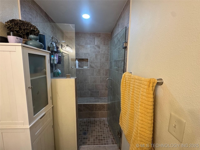 bathroom with a shower with door