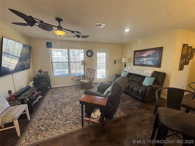 living room with ceiling fan and a wood stove