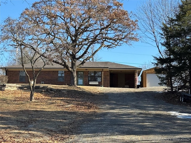 ranch-style home with a garage and an outbuilding