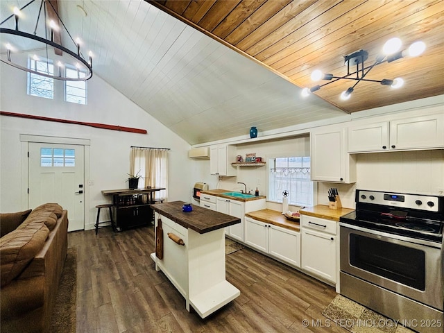 kitchen with stainless steel range with electric stovetop, white cabinetry, butcher block counters, and a notable chandelier