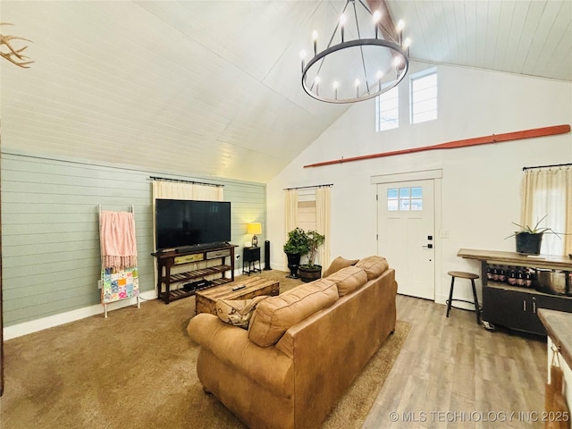 living room with wood ceiling, hardwood / wood-style flooring, a chandelier, wooden walls, and high vaulted ceiling