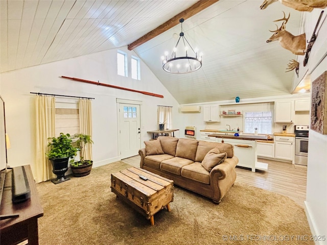 carpeted living room with a wall unit AC, a healthy amount of sunlight, beam ceiling, and an inviting chandelier