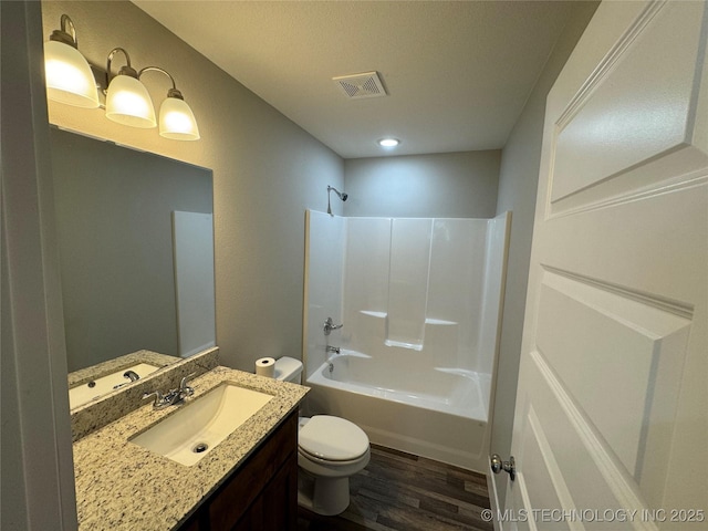 full bathroom with hardwood / wood-style floors, vanity,  shower combination, and toilet