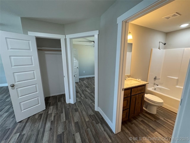 full bathroom with bathtub / shower combination, vanity, hardwood / wood-style flooring, and toilet