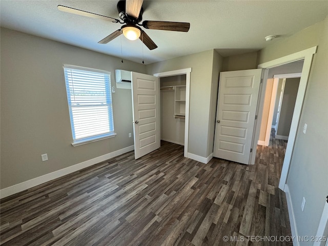 unfurnished bedroom with a wall mounted air conditioner, ceiling fan, dark hardwood / wood-style floors, and a closet