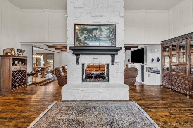 living room featuring a fireplace, ornamental molding, and dark hardwood / wood-style floors