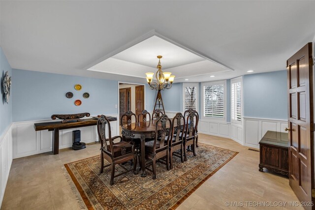 dining space with a notable chandelier and a tray ceiling