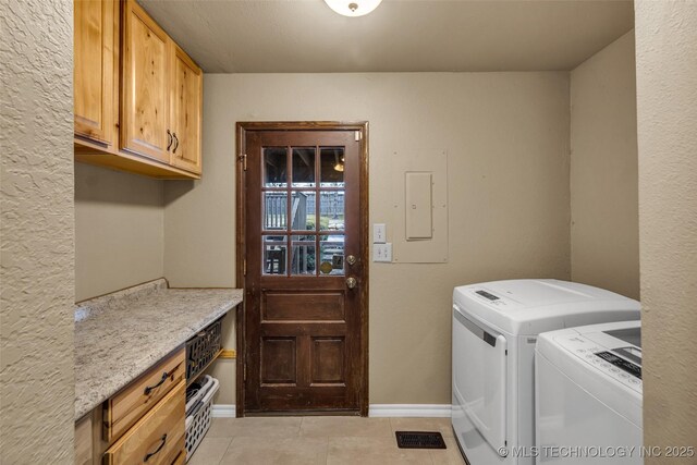 laundry area with cabinets, independent washer and dryer, electric panel, and light tile patterned floors