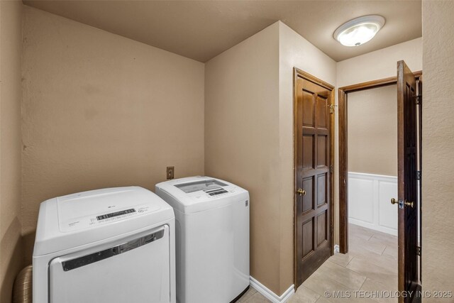 washroom with separate washer and dryer and light tile patterned floors