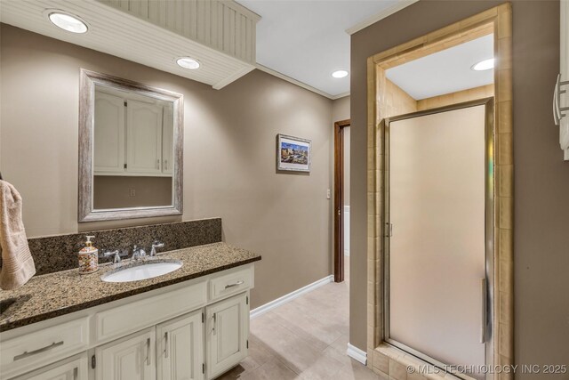 bathroom with crown molding, vanity, and a shower with shower door