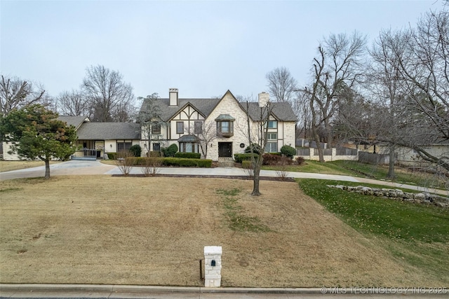 tudor home featuring a front lawn