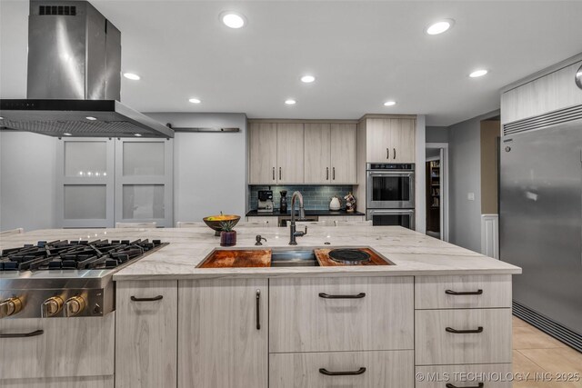 kitchen with sink, decorative backsplash, island exhaust hood, light stone counters, and stainless steel appliances