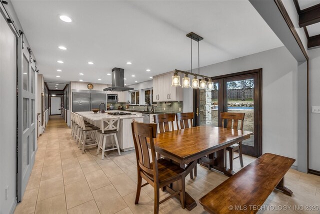 dining room with light tile patterned flooring and a barn door