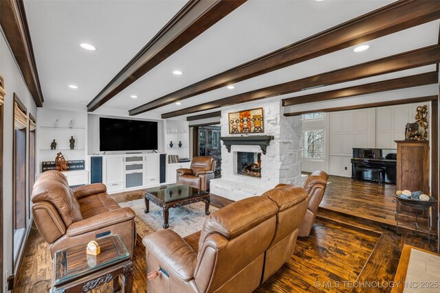 living room with beam ceiling, ornamental molding, dark hardwood / wood-style floors, built in features, and a fireplace