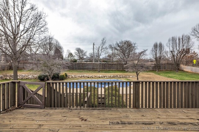 wooden terrace featuring a covered pool and a yard