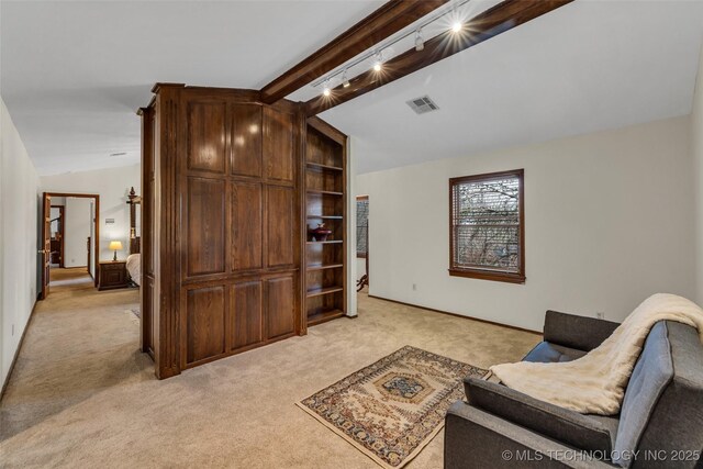 carpeted living room with vaulted ceiling and rail lighting