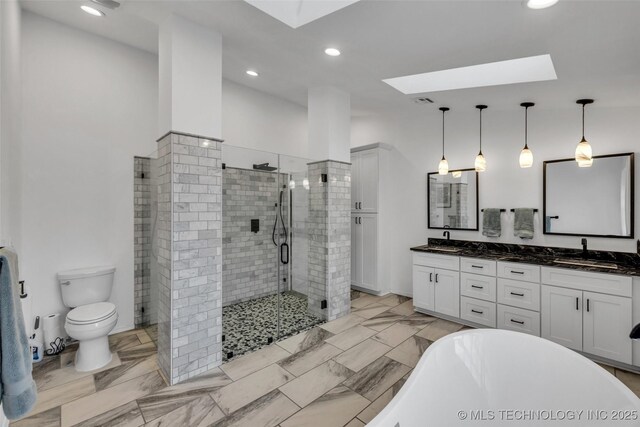 full bathroom featuring toilet, vanity, shower with separate bathtub, and a skylight