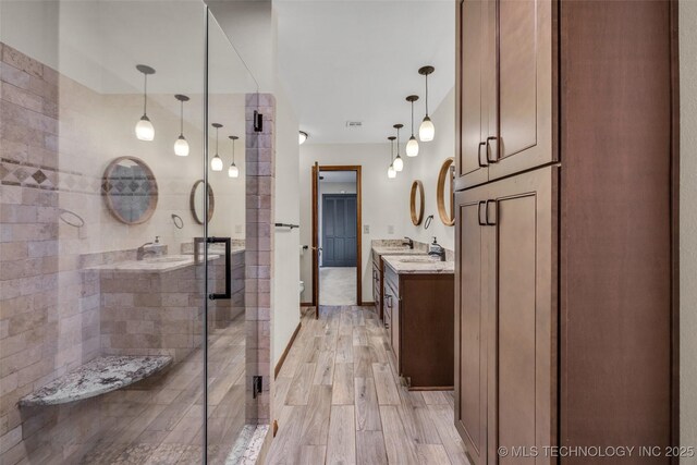 bathroom featuring vanity, hardwood / wood-style flooring, and a shower with door