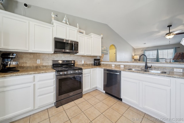 kitchen with white cabinetry, sink, vaulted ceiling, light tile patterned flooring, and appliances with stainless steel finishes