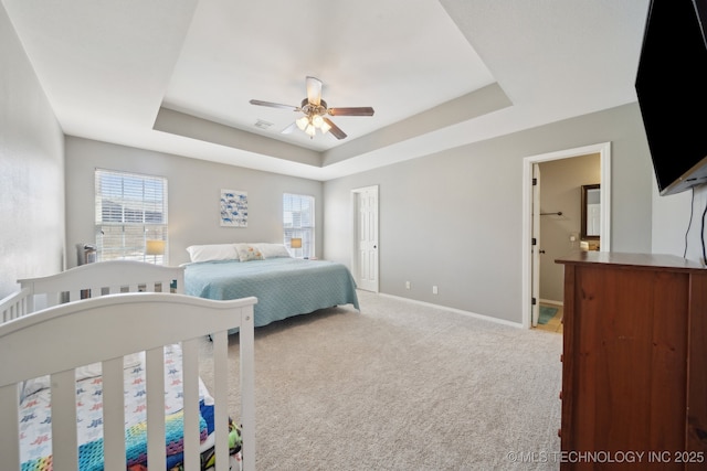 carpeted bedroom with ceiling fan and a raised ceiling