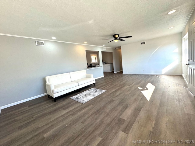 unfurnished living room featuring ceiling fan, dark wood-type flooring, and a textured ceiling