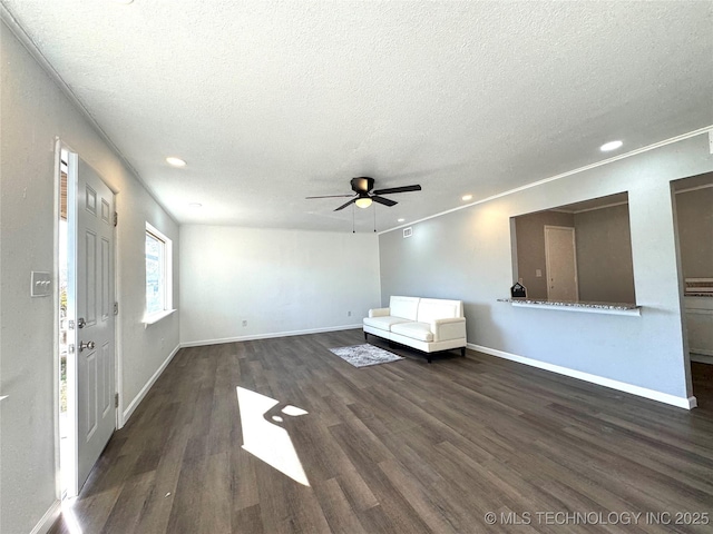 unfurnished living room featuring ceiling fan, dark wood-type flooring, and a textured ceiling