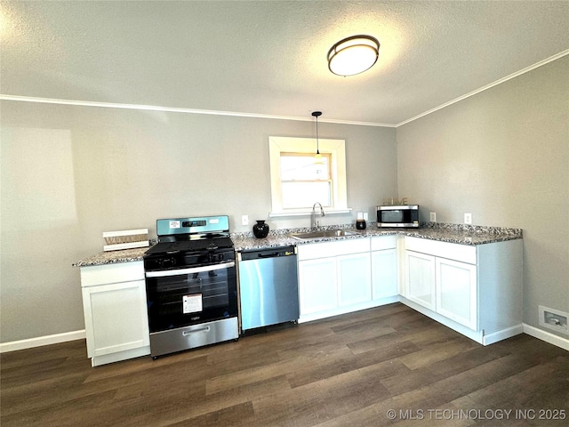 kitchen with appliances with stainless steel finishes, white cabinets, hanging light fixtures, and sink