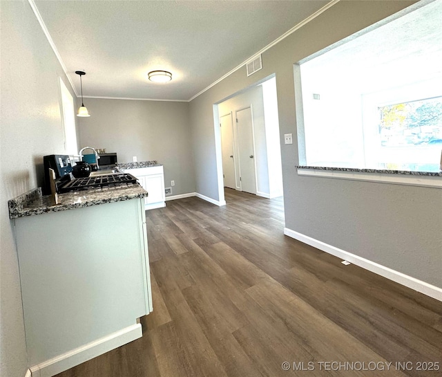 kitchen featuring a textured ceiling, white cabinets, hanging light fixtures, dark hardwood / wood-style floors, and crown molding