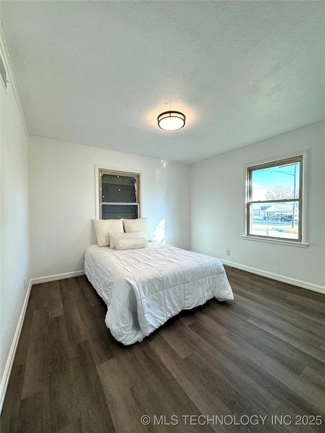 bedroom featuring a textured ceiling and dark wood-type flooring