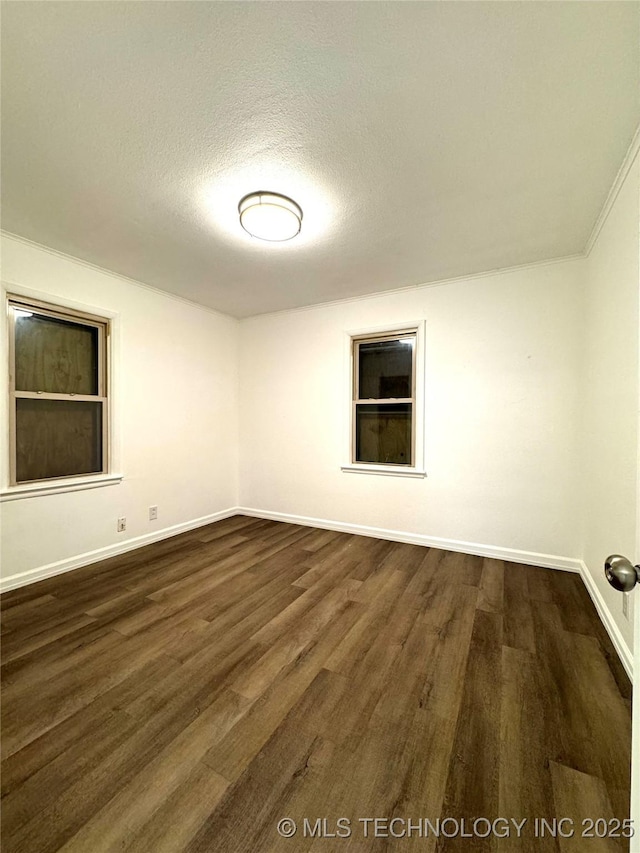 empty room featuring dark wood-type flooring and a textured ceiling